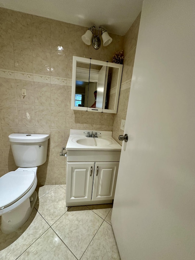 bathroom featuring vanity, tile walls, toilet, and tile patterned flooring