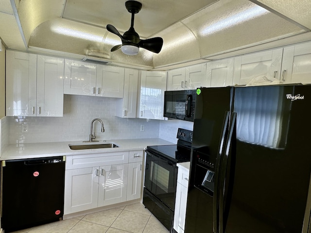 kitchen with light tile patterned flooring, a sink, black appliances, light countertops, and white cabinetry