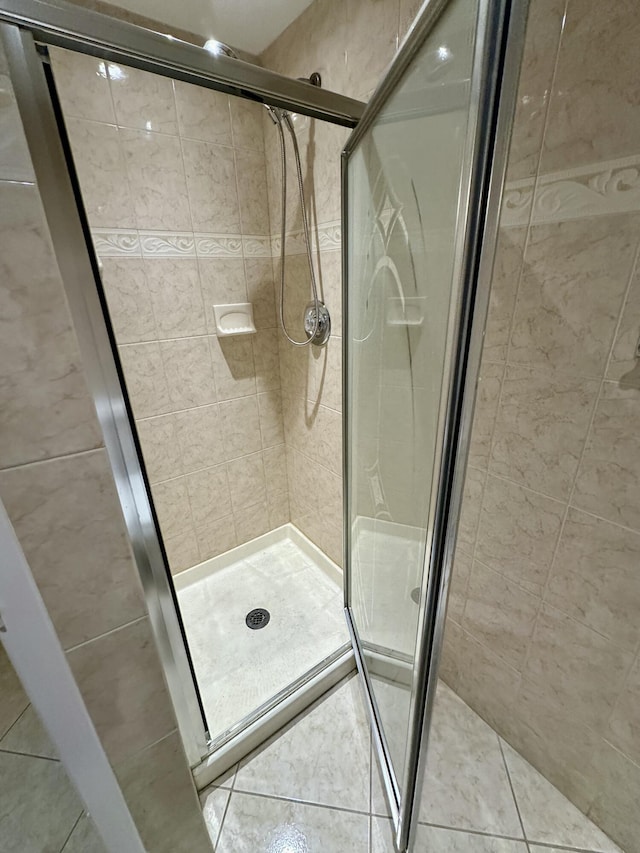 full bath with tile patterned floors and a shower stall