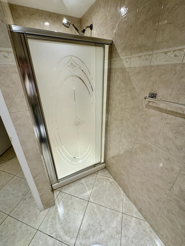 full bathroom featuring tile patterned flooring, tile walls, and a stall shower