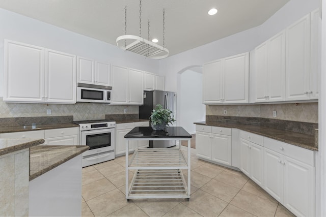 kitchen featuring white cabinetry, decorative backsplash, and white appliances