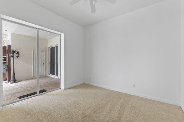 unfurnished bedroom featuring a ceiling fan, carpet, and baseboards