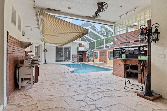 pool featuring area for grilling, a bar, a patio, and glass enclosure