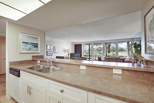 kitchen with a sink, a textured ceiling, dishwasher, and white cabinets