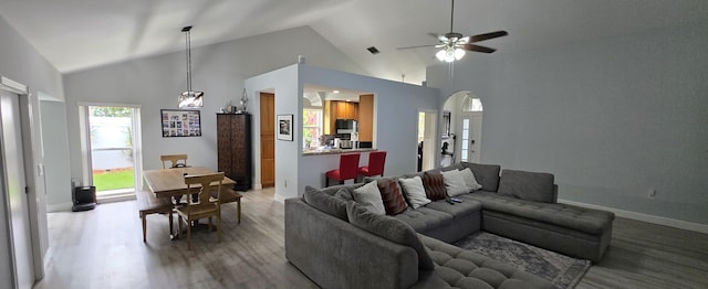 2285 Saratoga Ln, West Palm Beach, FL 33409 - living room with high vaulted ceiling, arched walkways, a ceiling fan, light wood finished floors, and baseboards