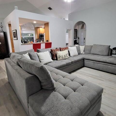 2285 Saratoga Ln, West Palm Beach, FL 33409 - living room with arched walkways, visible vents, wood finished floors, and lofted ceiling