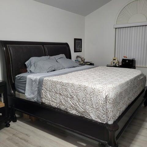 2285 Saratoga Ln, West Palm Beach, FL 33409 - bedroom with wood finished floors and vaulted ceiling