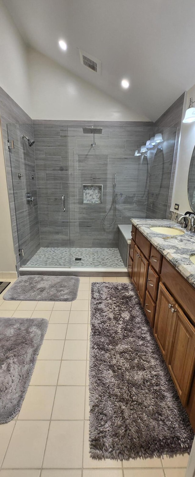 2285 Saratoga Ln, West Palm Beach, FL 33409 - bathroom with visible vents, double vanity, tile patterned floors, a stall shower, and lofted ceiling