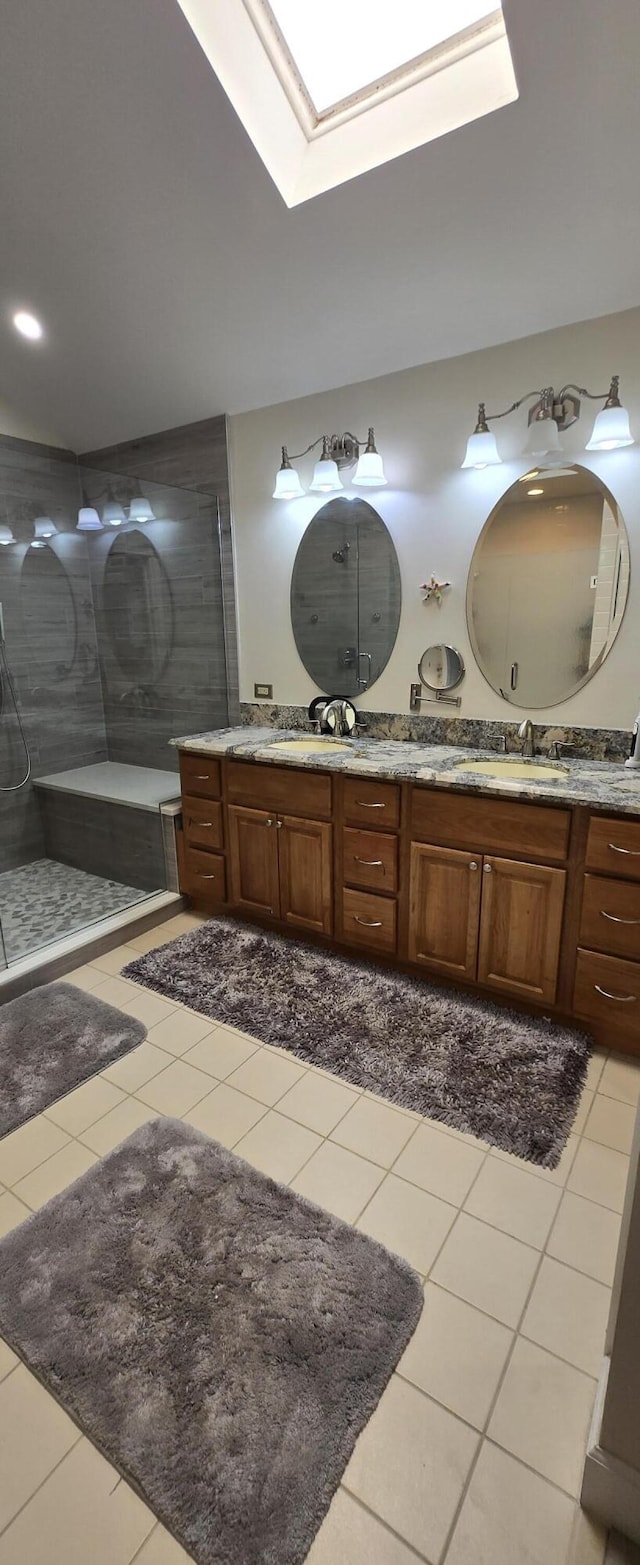2285 Saratoga Ln, West Palm Beach, FL 33409 - bathroom with a tile shower, tile patterned floors, a skylight, and double vanity