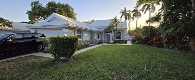 2285 Saratoga Ln, West Palm Beach, FL 33409 - view of front of house featuring a front yard, stucco siding, and an attached garage