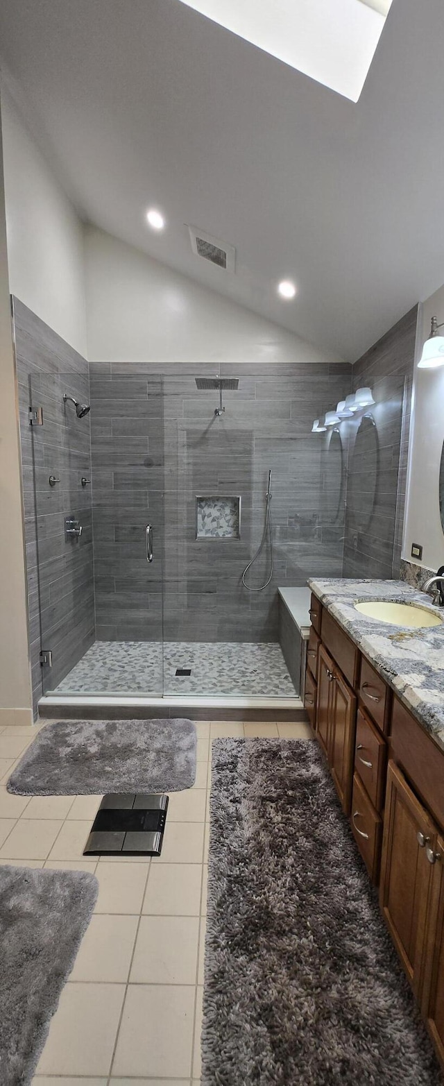 2285 Saratoga Ln, West Palm Beach, FL 33409 - full bathroom featuring vanity, visible vents, lofted ceiling, a stall shower, and tile patterned floors