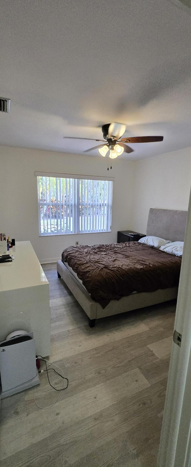 2285 Saratoga Ln, West Palm Beach, FL 33409 - bedroom featuring visible vents, a ceiling fan, wood finished floors, and a textured ceiling