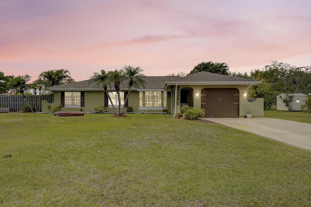 single story home featuring a garage, driveway, stucco siding, and a front lawn