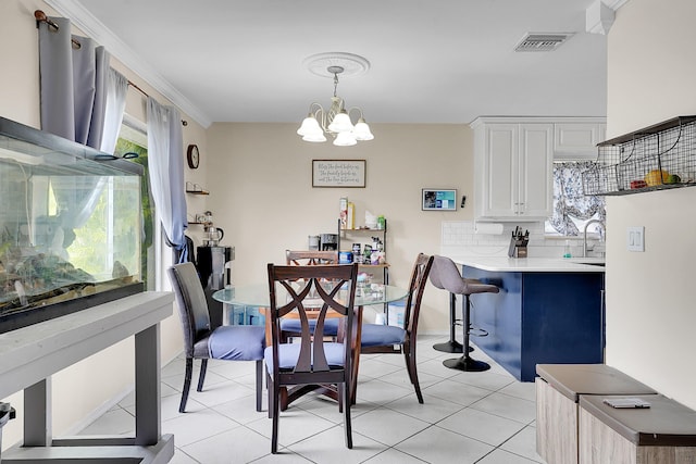 dining space featuring an inviting chandelier, light tile patterned flooring, crown molding, and visible vents