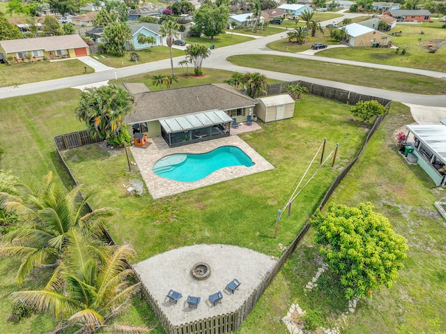 view of swimming pool featuring a fenced in pool, a fenced backyard, a residential view, an outbuilding, and a patio area