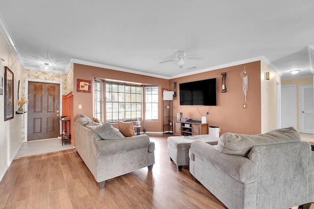 living area featuring baseboards, light wood-style flooring, ornamental molding, and a ceiling fan