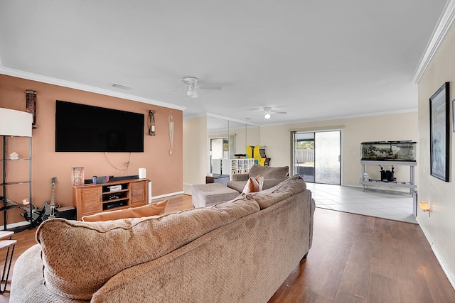 living area featuring crown molding, a ceiling fan, wood finished floors, baseboards, and visible vents