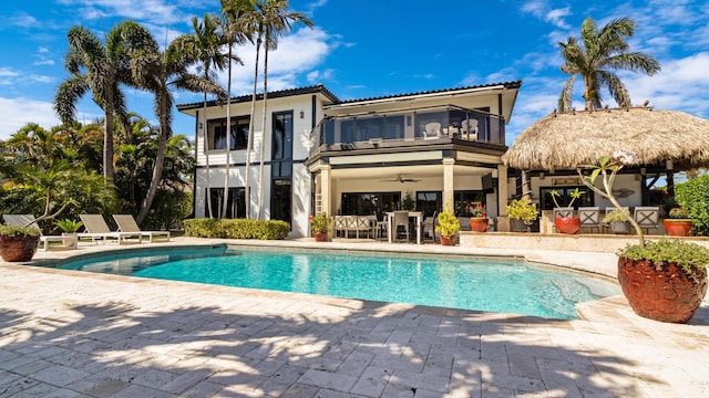 1526 SE 11th St, Deerfield Beach, FL 33441 - rear view of house with a patio area, a balcony, a ceiling fan, an outdoor pool, and stucco siding