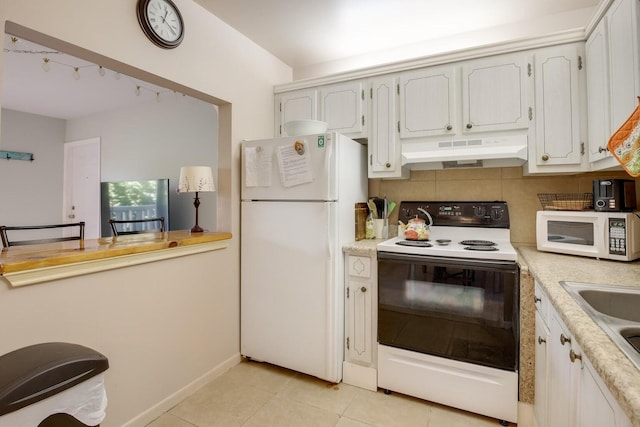 95 N N Blvd Unit 2B, Boynton Beach, FL 33435 - kitchen featuring under cabinet range hood, light countertops, light tile patterned floors, and white appliances