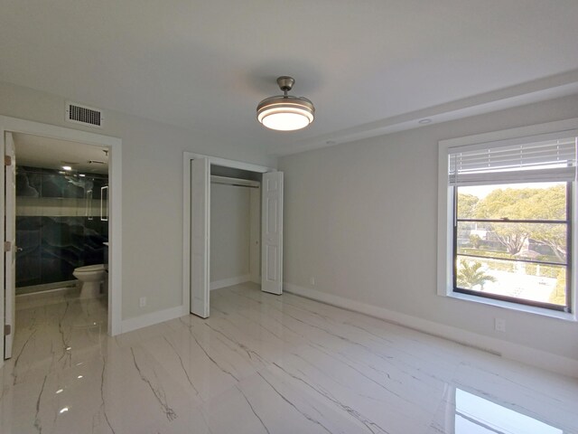 7240 Huntington Ln Unit 408, Delray Beach, FL 33446 - unfurnished bedroom featuring marble look tile flooring, a closet, baseboards, and ensuite bath