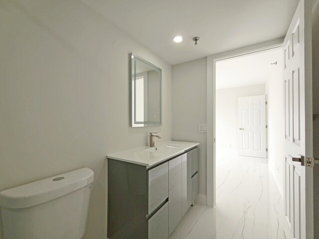 7240 Huntington Ln Unit 408, Delray Beach, FL 33446 - bathroom with marble finish flooring, toilet, vanity, recessed lighting, and baseboards