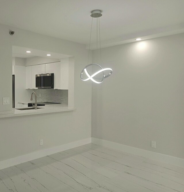 7240 Huntington Ln Unit 408, Delray Beach, FL 33446 - kitchen with light marble finish flooring, white cabinets, light countertops, recessed lighting, and hanging light fixtures