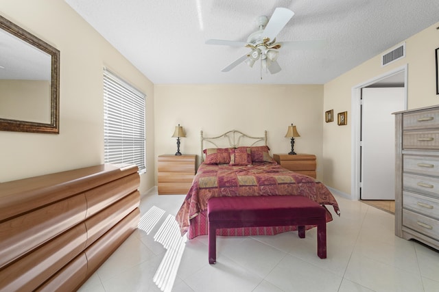 14112 Huntington Pointe Dr Unit 105, Delray Beach, FL 33484 - bedroom featuring light tile patterned floors, visible vents, a textured ceiling, and ceiling fan