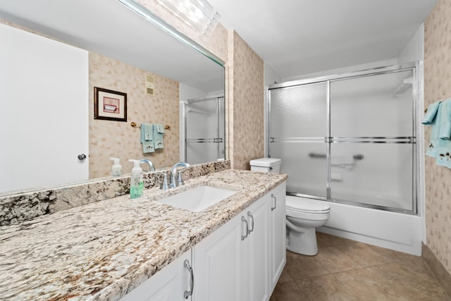 14112 Huntington Pointe Dr Unit 105, Delray Beach, FL 33484 - full bathroom featuring toilet, wallpapered walls, tile patterned flooring, bath / shower combo with glass door, and vanity