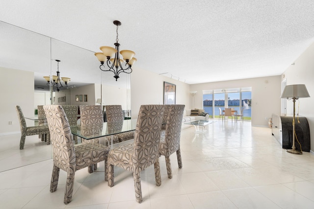 14112 Huntington Pointe Dr Unit 105, Delray Beach, FL 33484 - tiled dining space featuring baseboards, a textured ceiling, and an inviting chandelier