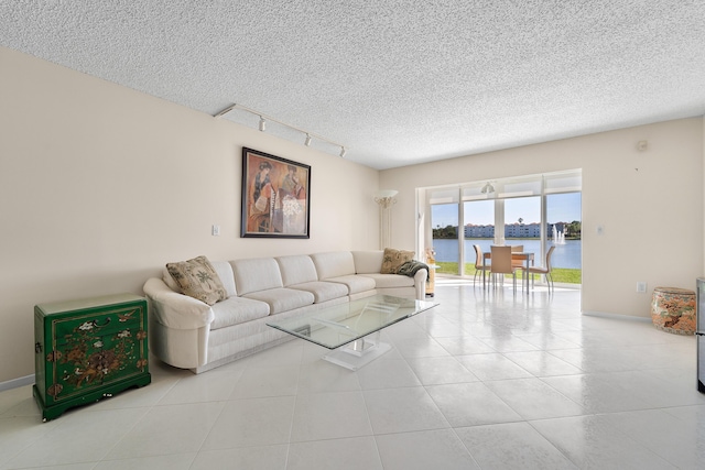 14112 Huntington Pointe Dr Unit 105, Delray Beach, FL 33484 - living room featuring tile patterned floors, a water view, a textured ceiling, and rail lighting