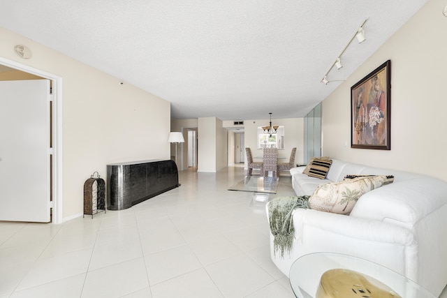 14112 Huntington Pointe Dr Unit 105, Delray Beach, FL 33484 - living room featuring light tile patterned flooring, a chandelier, and a textured ceiling