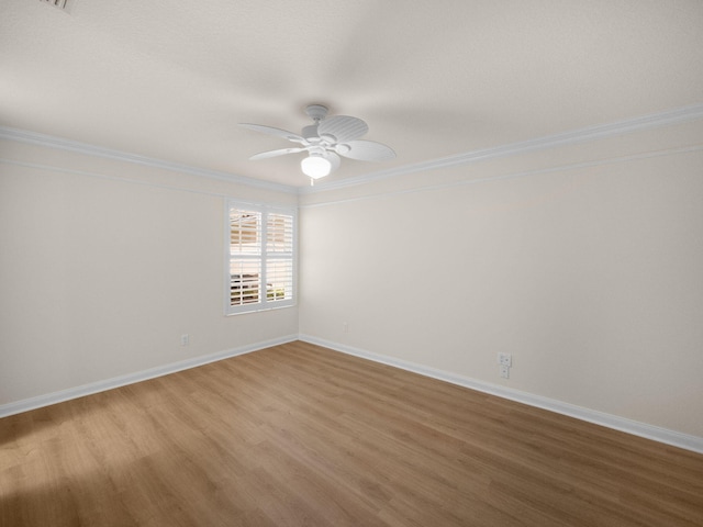 unfurnished room with a ceiling fan, baseboards, ornamental molding, and wood finished floors