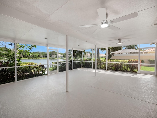unfurnished sunroom with a water view and ceiling fan