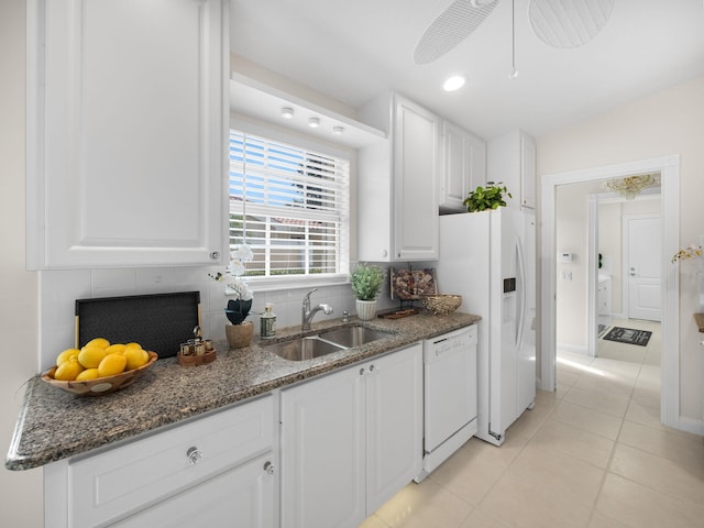 kitchen with white cabinets, a sink, decorative backsplash, white appliances, and light tile patterned floors