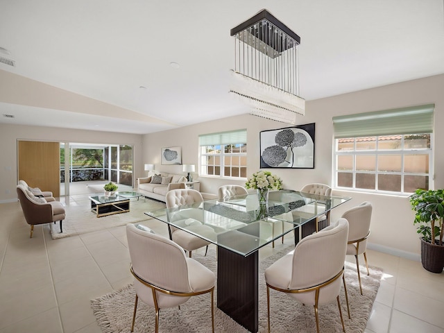 tiled dining room with lofted ceiling, a wealth of natural light, and baseboards