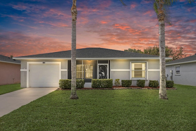 ranch-style house featuring a shingled roof, a front yard, stucco siding, and an attached garage