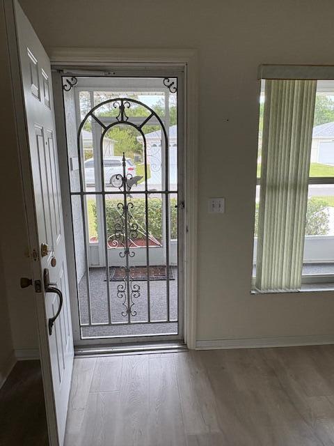 entryway with baseboards and wood finished floors