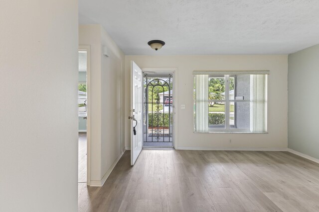 unfurnished room featuring baseboards, visible vents, and wood finished floors