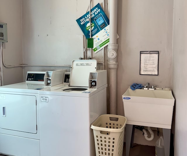common laundry area with independent washer and dryer and a sink