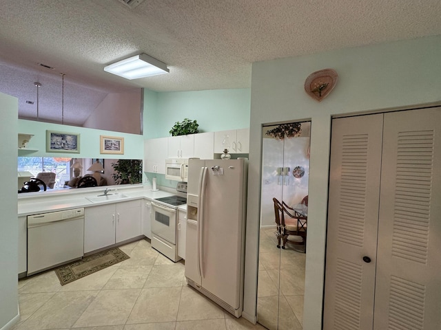 kitchen featuring a sink, white cabinetry, white appliances, light countertops, and lofted ceiling