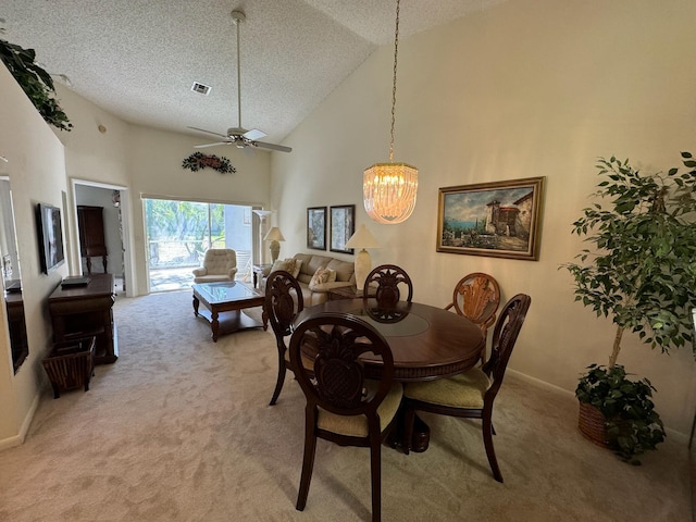 dining area featuring light carpet, a textured ceiling, and high vaulted ceiling