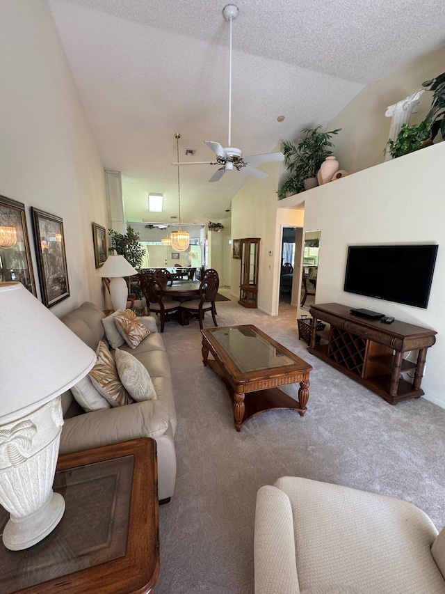 carpeted living room with a textured ceiling, high vaulted ceiling, visible vents, and ceiling fan