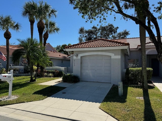 mediterranean / spanish-style home with a front lawn, a tile roof, stucco siding, driveway, and an attached garage