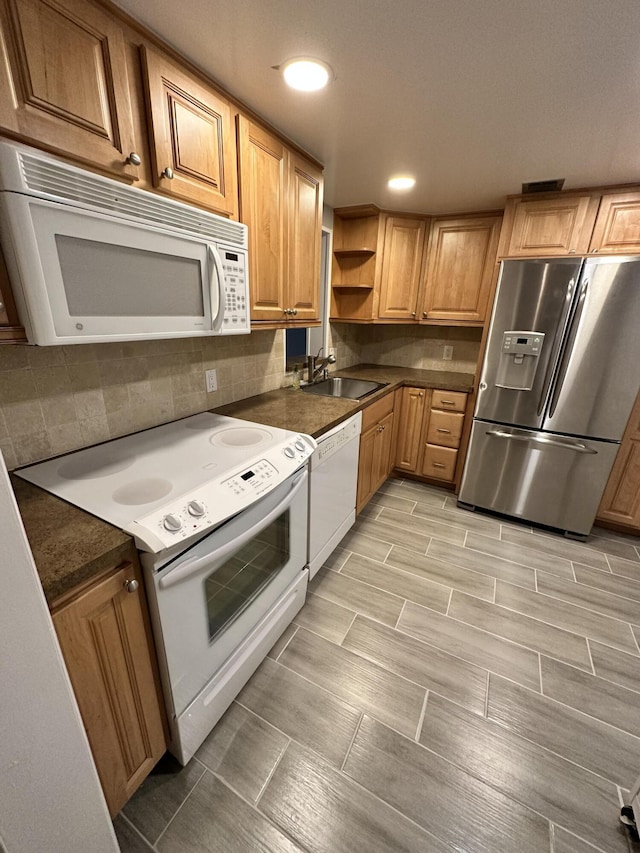 kitchen featuring dark countertops, open shelves, a sink, white appliances, and backsplash