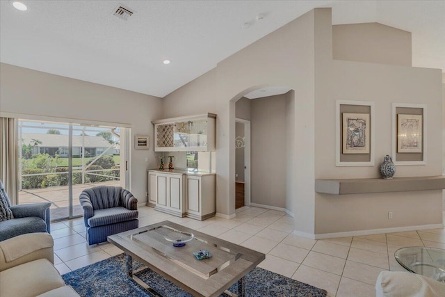 living area featuring light tile patterned floors, high vaulted ceiling, baseboards, arched walkways, and visible vents