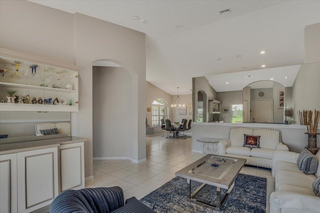 living room with an inviting chandelier, light tile patterned flooring, arched walkways, and lofted ceiling