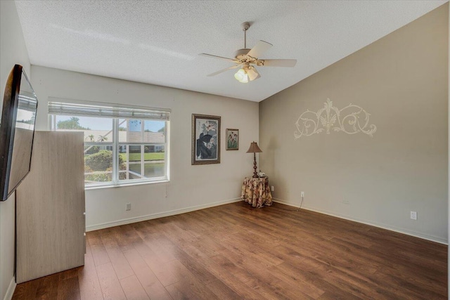 spare room featuring a textured ceiling, baseboards, ceiling fan, and wood finished floors