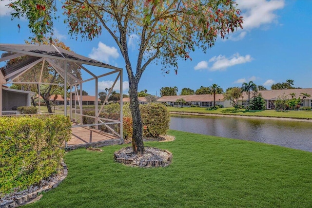 view of yard featuring a residential view, a water view, and a lanai