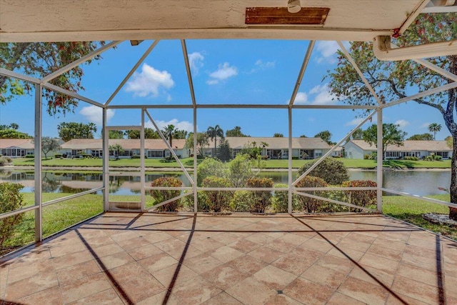 view of patio / terrace featuring a residential view, a water view, and glass enclosure