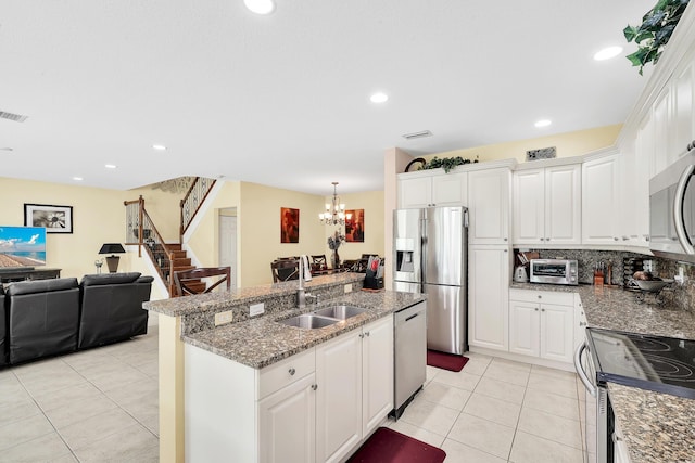 kitchen with light tile patterned floors, white cabinetry, stainless steel appliances, and a sink